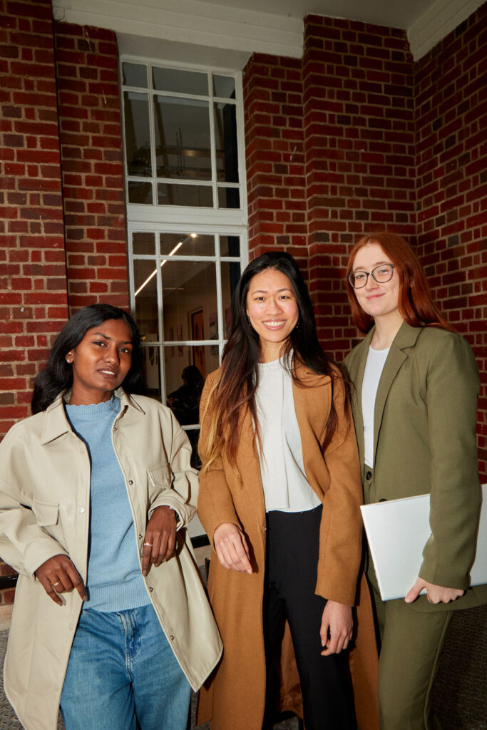 Friends enjoying the outdoors: Three students socializing outside of campus regent's university in London