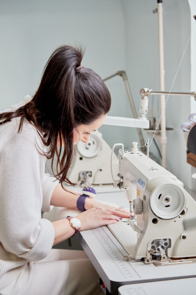 Fashion design student sewing her creation at Regents University London